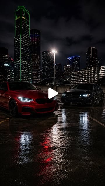 Cover: a red BMW and a black Audi in a rainy parking garage, Dallas skyline at night