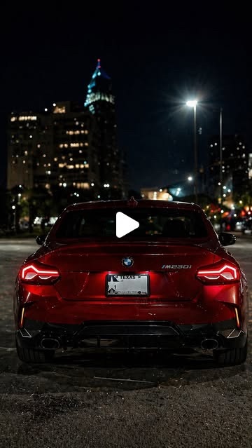Cover: the rear of a red BMW 230i at night