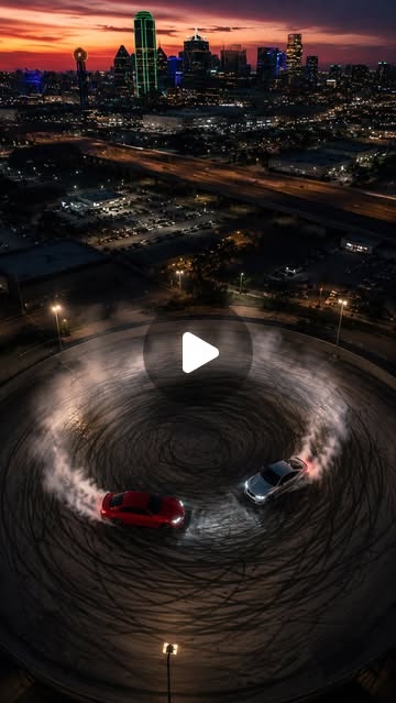 Cover: two cars drifting in circles on a Dallas rooftop at sunset, seen from above