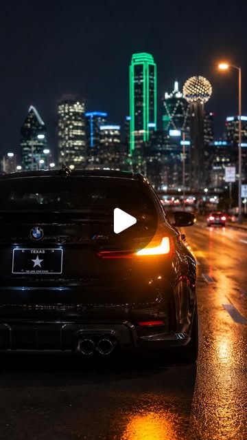 Cover: a black BMW parked on a wet Dallas street at night, the skyline behind it